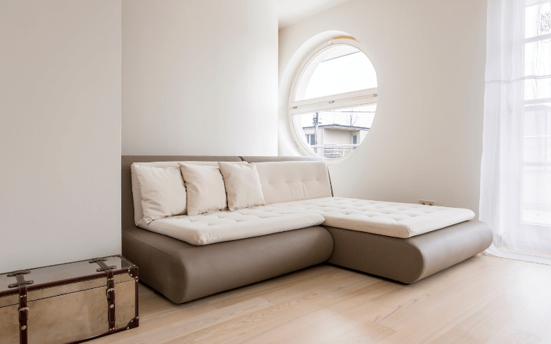 An image of a sofa bed or storage ottoman in a stylish, compact living room.