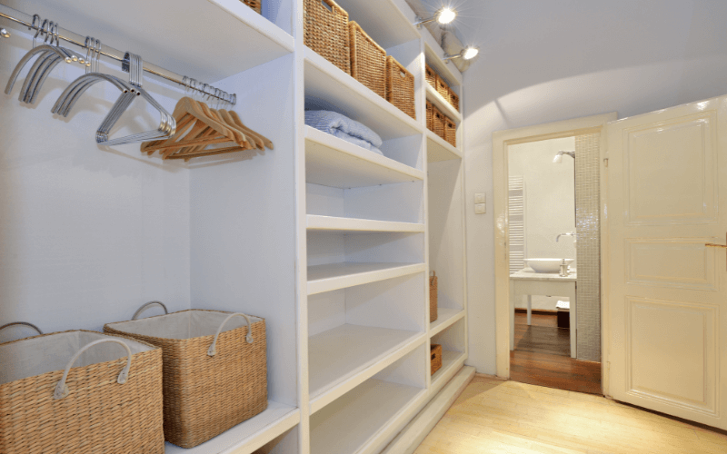 An image of a well-organised closet with extra shelves and bins for vertical storage.
