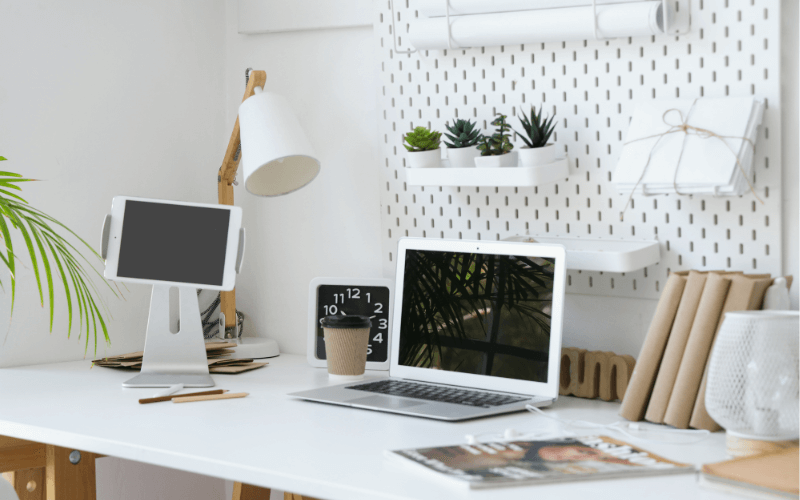 Image of a workoffice desk with a wall-mounted shelf, including pegboards, and a built-in cabinet for the desk.