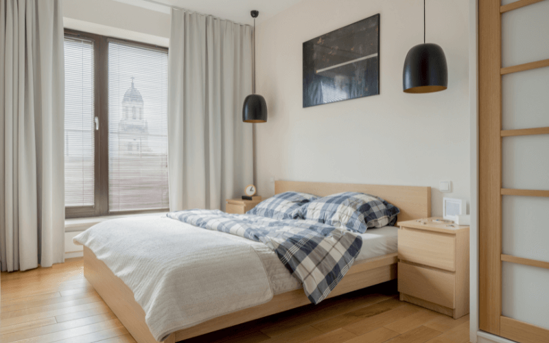 Image of a simple bedroom with just the bare minimum. One bed, a wardrobe, and a nightstand. It’s like a blank canvas for a bedroom design.