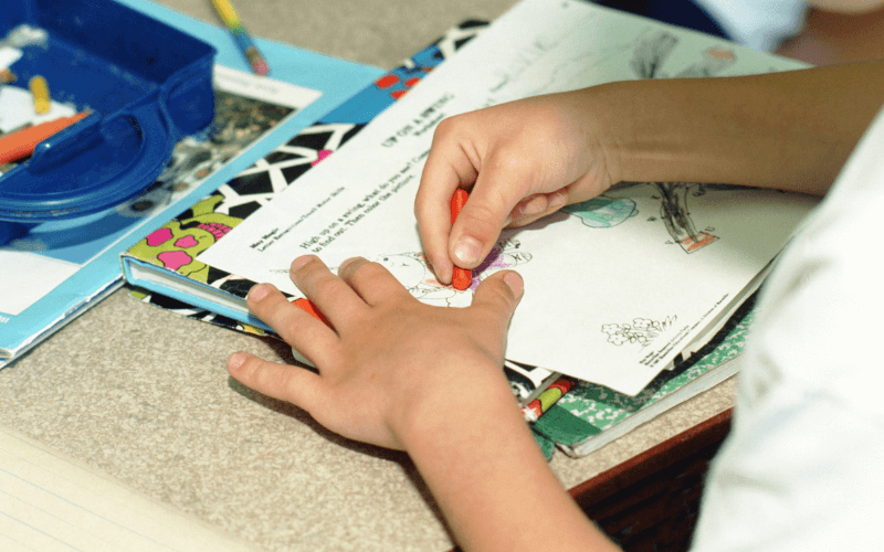 An image of a child colouring in a book