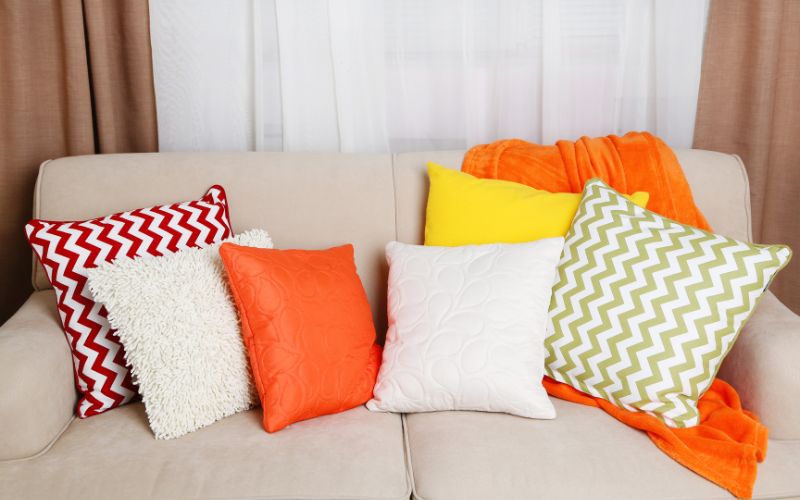 Image of a couch with a pillows that have fun and colorful patterns