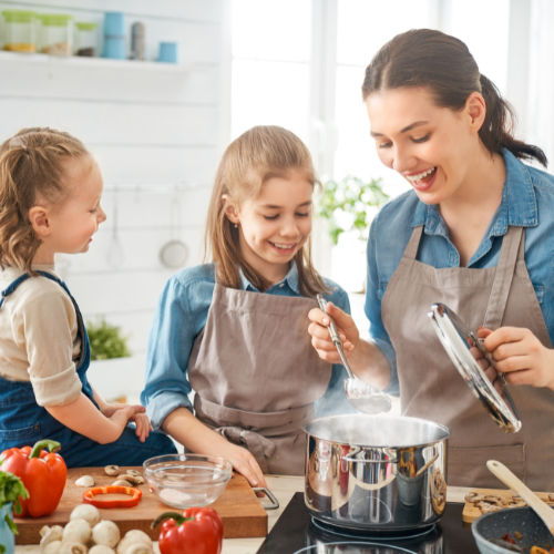 Small image of a parent cooking with their child watching and helping