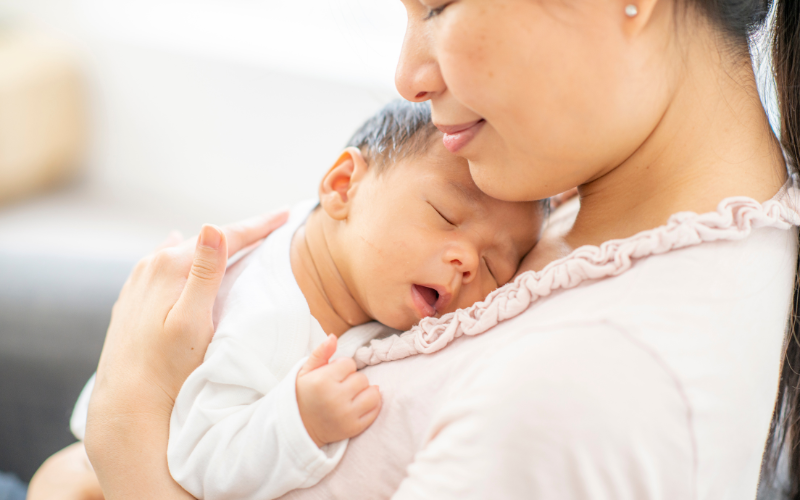 Mother holding newborn baby joyfully