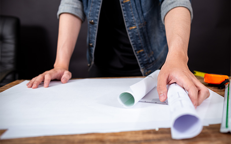 Image of a a person checking a blueprint