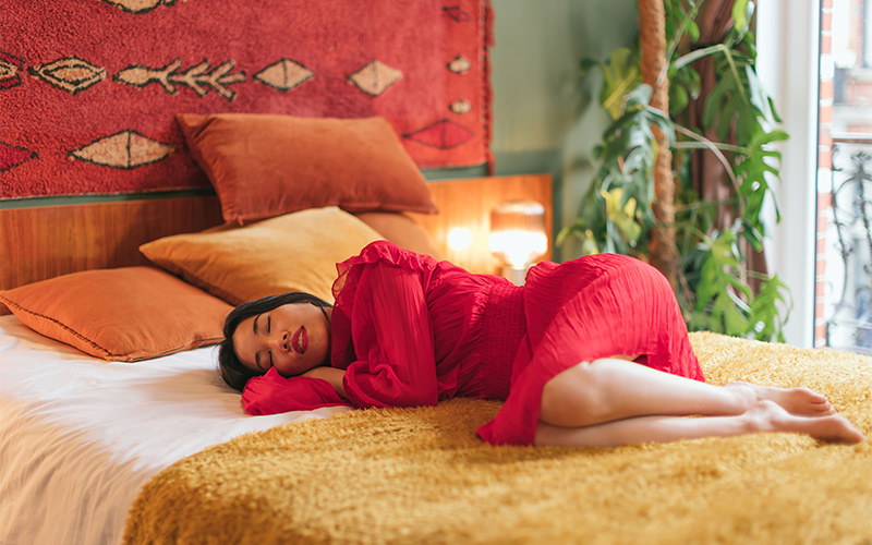 Image of a person sleeping on their very colourful bed