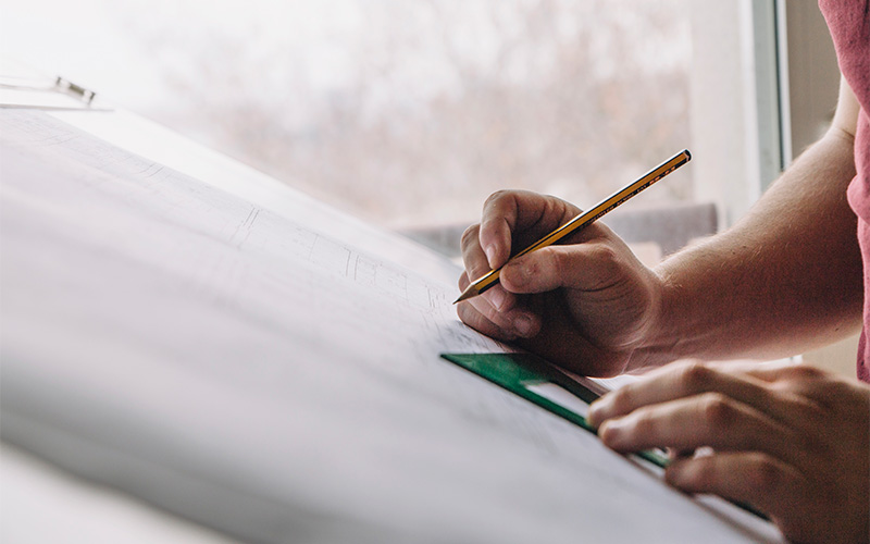 Image of a person with a pencil planning a layout