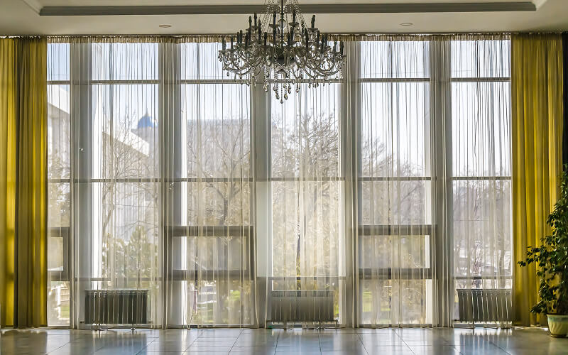 Image of a huge window with large drapes and curtains