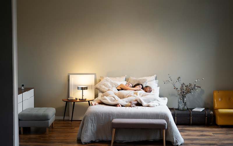 A cosy HDB bedroom with multi-functional furniture and soft lighting.