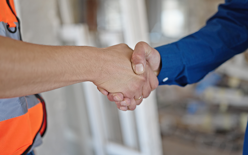 A contractor and homeowner shaking hands