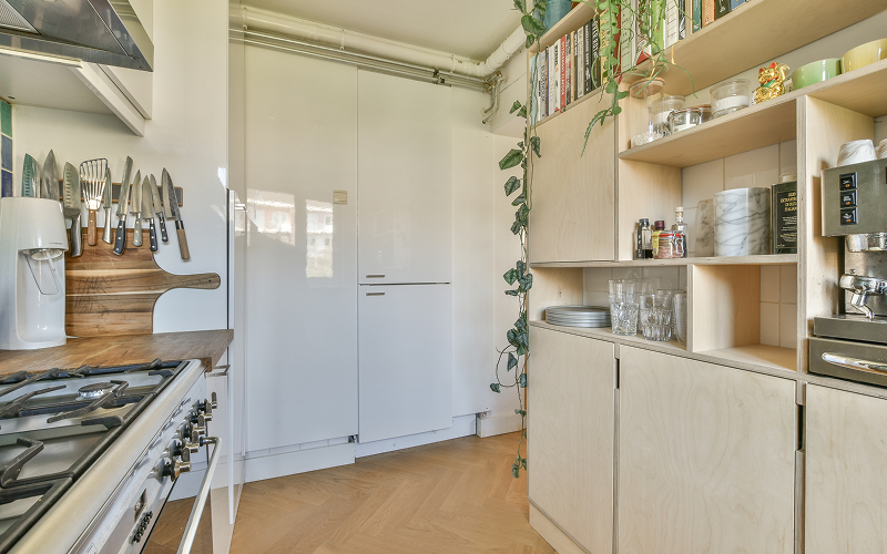 A kitchen with clean cabinets with a mix of open shelving and concealed storage.