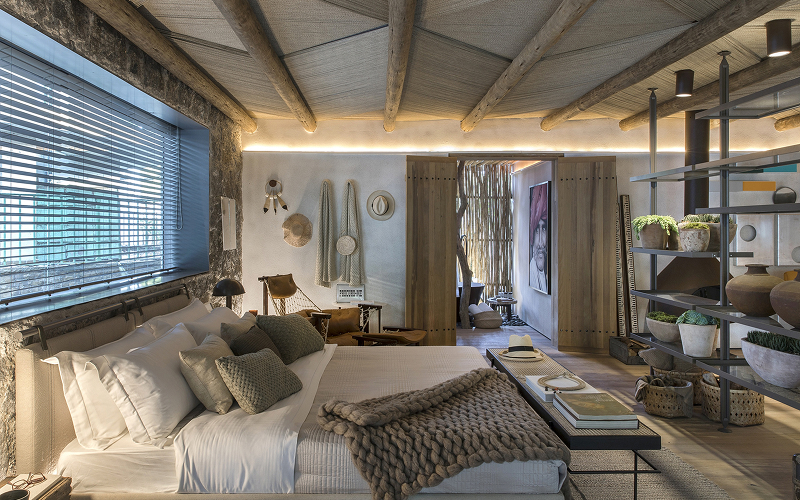 A styled HDB bedroom with an industrial look softened by warm lighting and earthy textiles.
