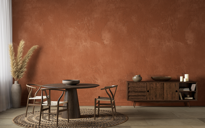A terracotta, taupe, or mustard-toned accent wall paired with black metal elements.