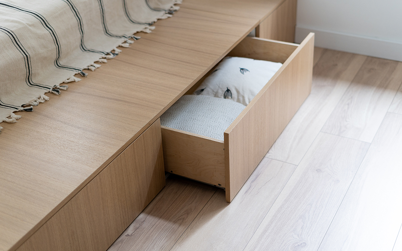 An image of an individual lifting a platform bed or sliding out hidden drawers.