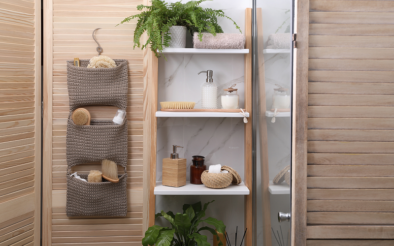 Bathroom accessories placed in a storage rack on a tiled surfacewall.