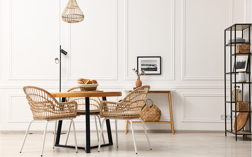 Minimalist dining area with a wooden table and rattan chairs