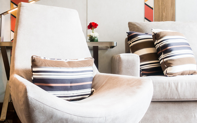A corner chair with cushions.