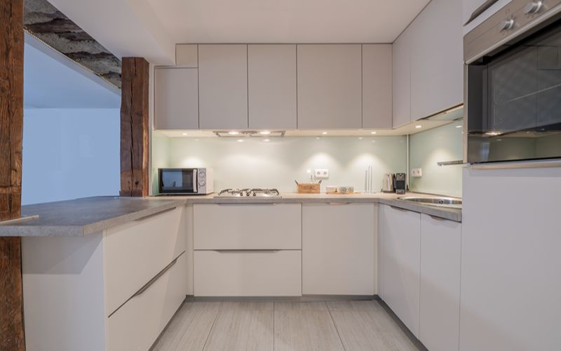 a simple lighting setup in a monochromatic kitchen