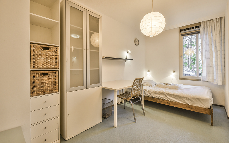 a small image of wall-mounted storage units in a small bedroom